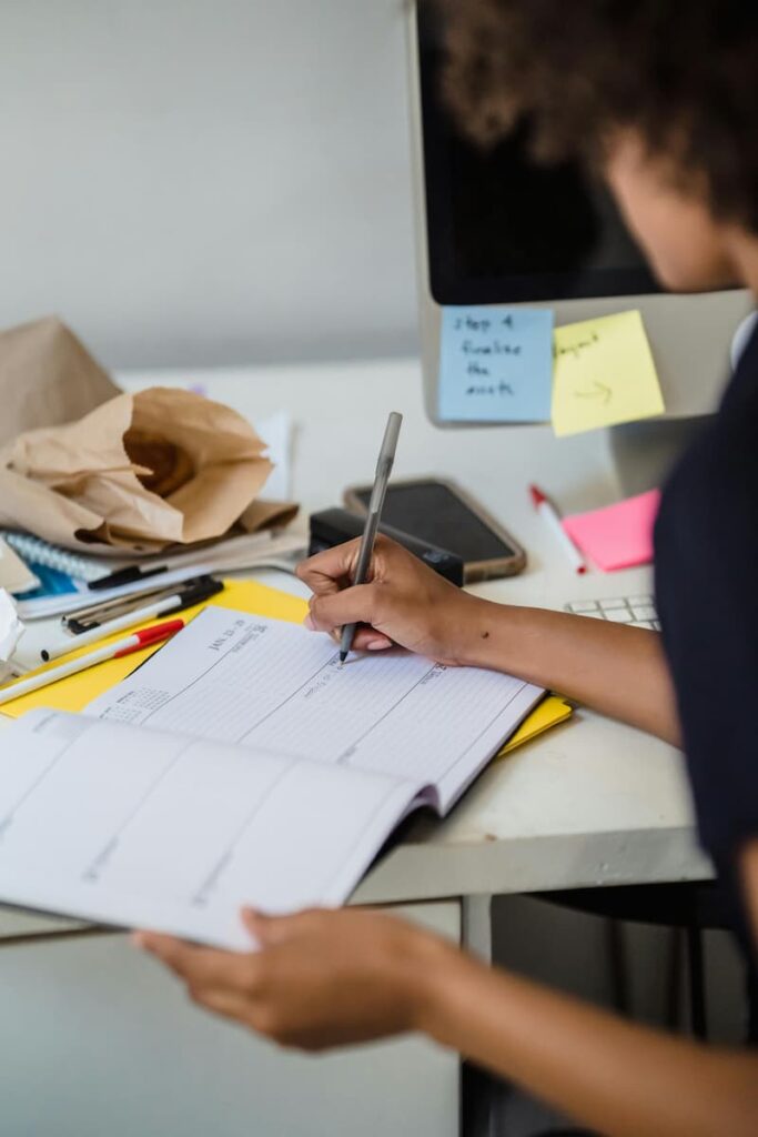 Woman writing in a planner to organize financial and life steps after release