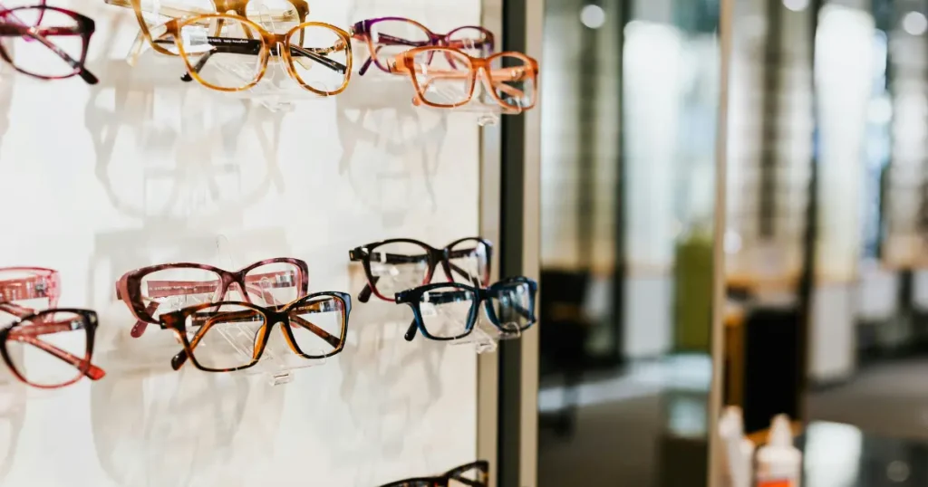 Rows of eyeglass frames displayed on a wall rack in an optical store
