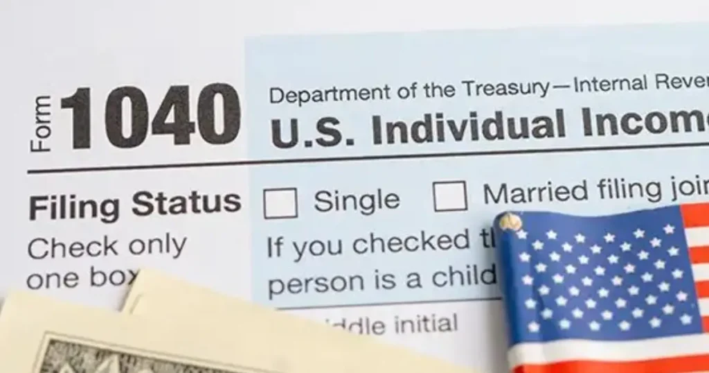 IRS Form 1040 US Individual Income Tax Return with a small American flag — federal tax filing document