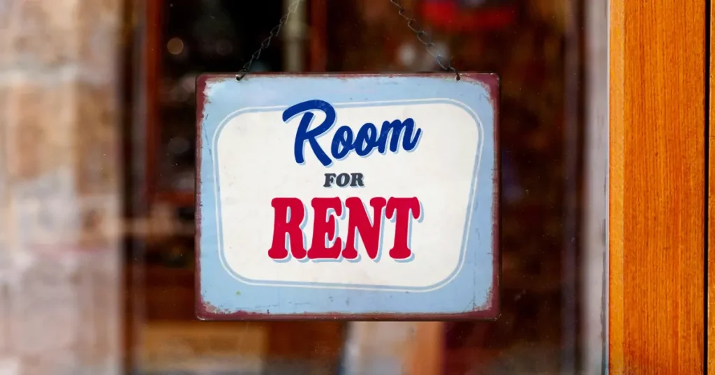 Vintage Room for Rent sign hanging on a wooden door