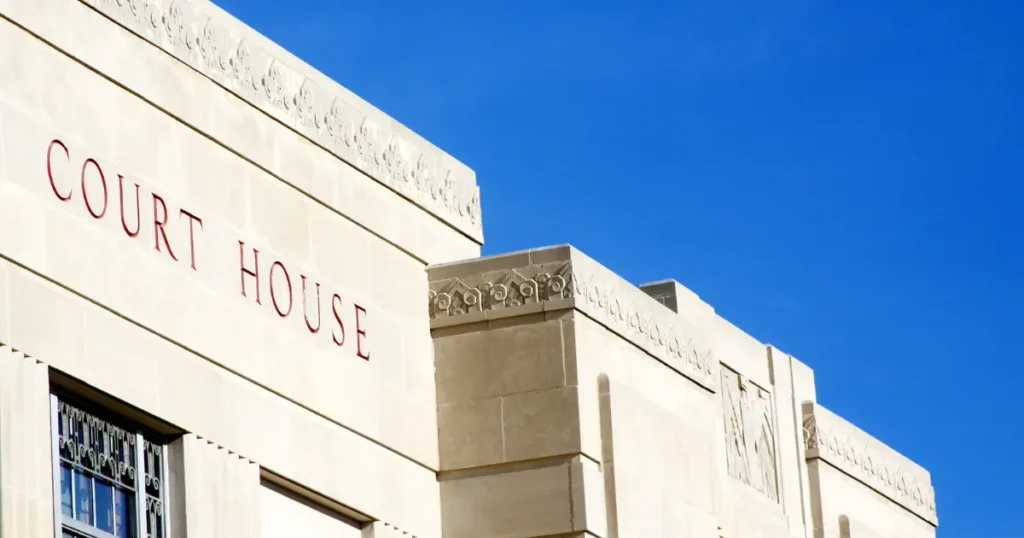 Courthouse exterior against blue sky representing the legal rights restoration process for people with felony convictions navigating voting rights firearm restrictions and expungement