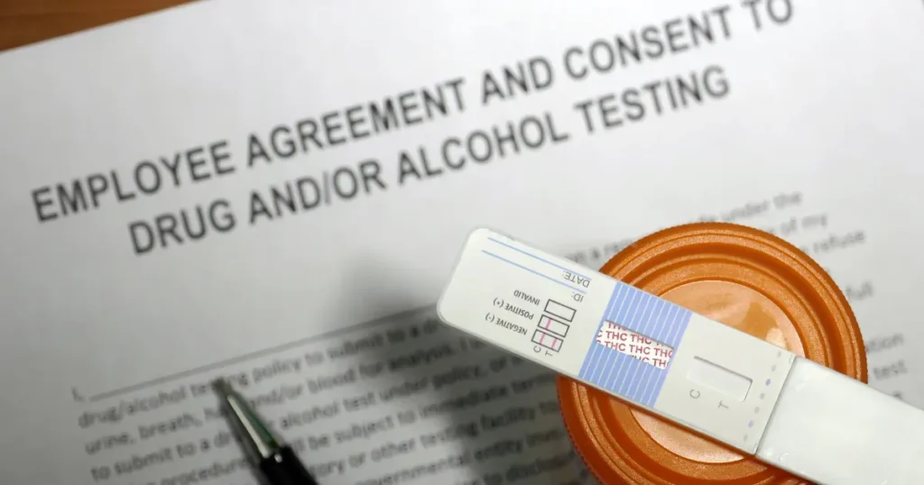Employee drug and alcohol testing consent form with a urine test strip and sample cup